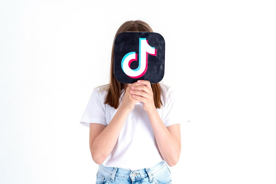 Image of a woman covering her face with a TikTok logo