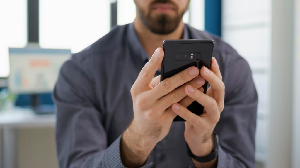 Man in long sleeves holding a smartphone